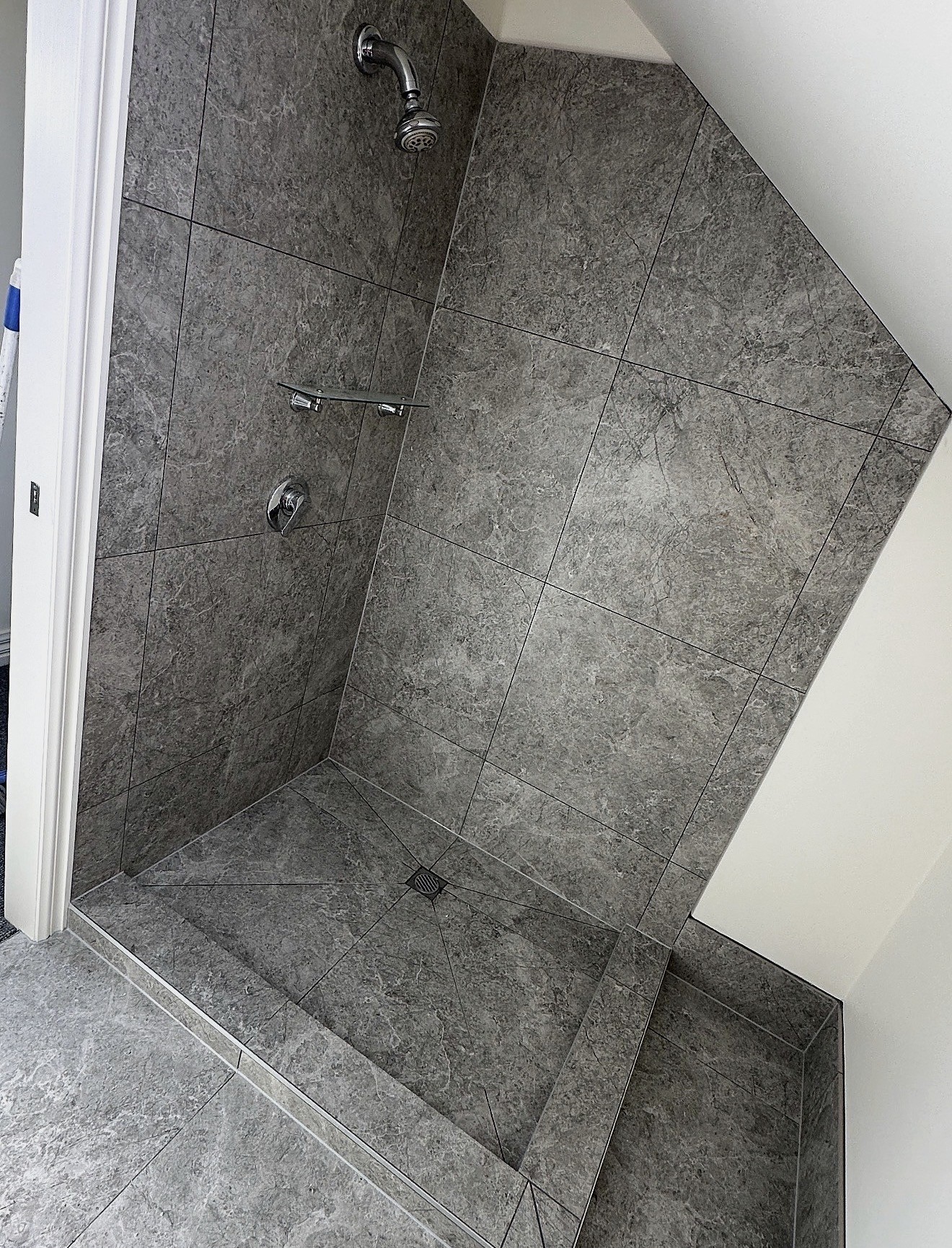 Completed shower with dark grey stone-look tiles